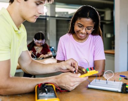 Teacher and student measuring the voltage of an electrical experiment.